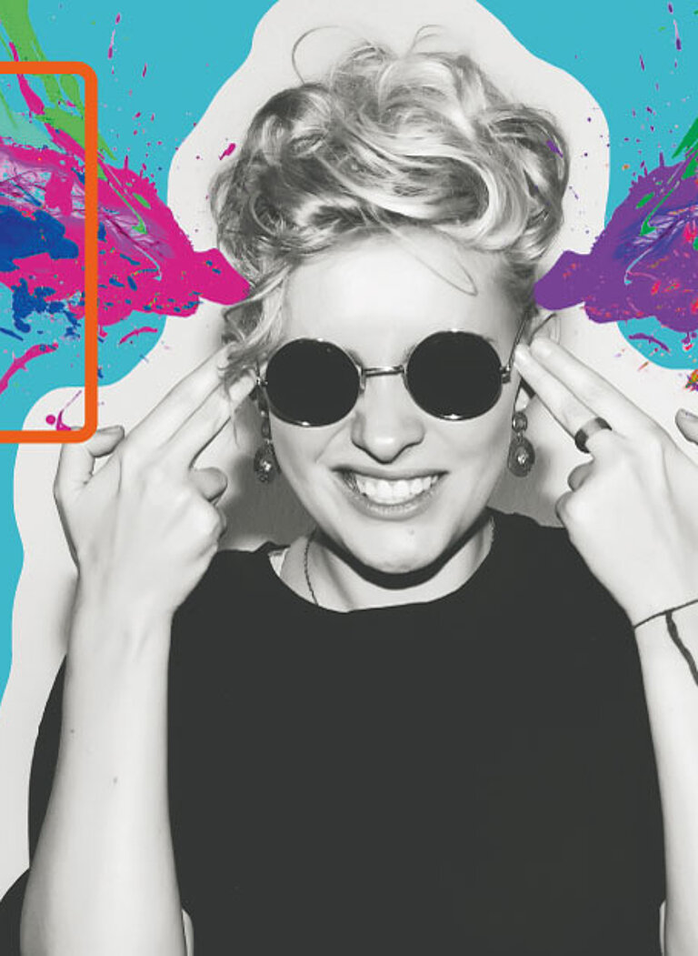 Grafisches Motiv mit den orange umrahmten Buchstaben ‚HIT‘ und der Zahl ‚25‘ auf hellblauem Hintergrund. Rechts eine Person mit Sonnenbrille und schwarzem Shirt, die lachend beide Hände wie Pistolen an den Kopf hält – bunte Farbspritzer in Pink, Grün und Blau explodieren seitlich aus dem Kopfbereich.